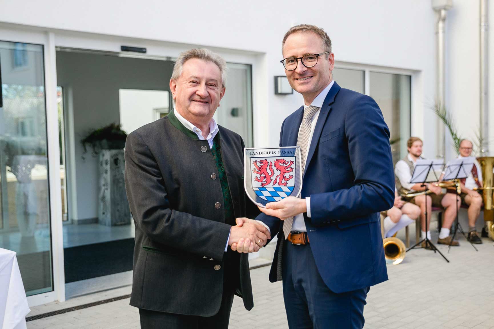 Landrat Franz Meyer (rechts) überreicht Klinikleiter Michael Hisch ein Glaswappen des Landkreises Passau.